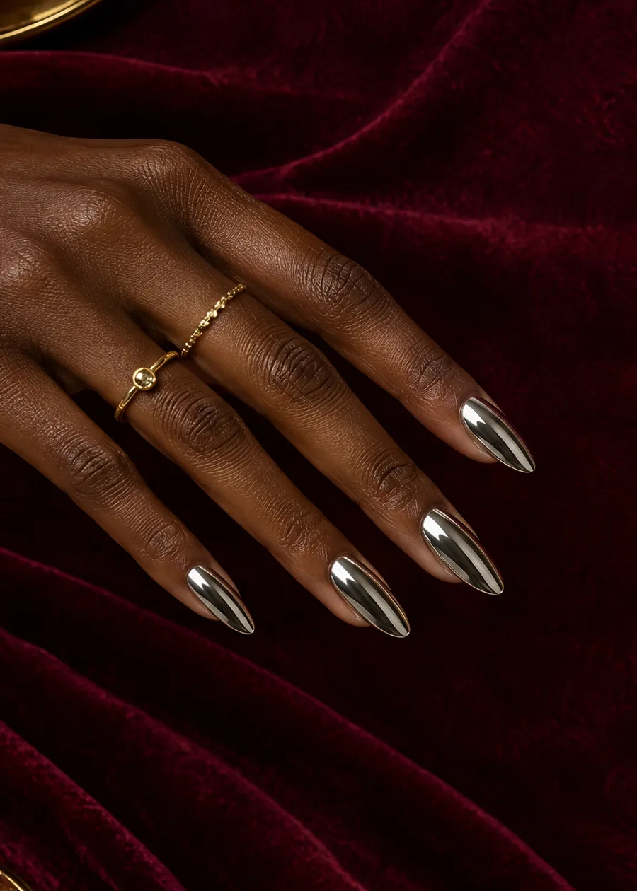 Deep brown hand with mirror silver chrome almond nails