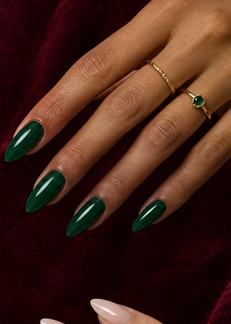 Olive hand with glossy emerald almond nails and gold rings